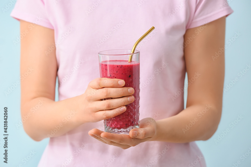 Woman with glass of fruit smoothie on color background - obrazy, fototapety, plakaty 
