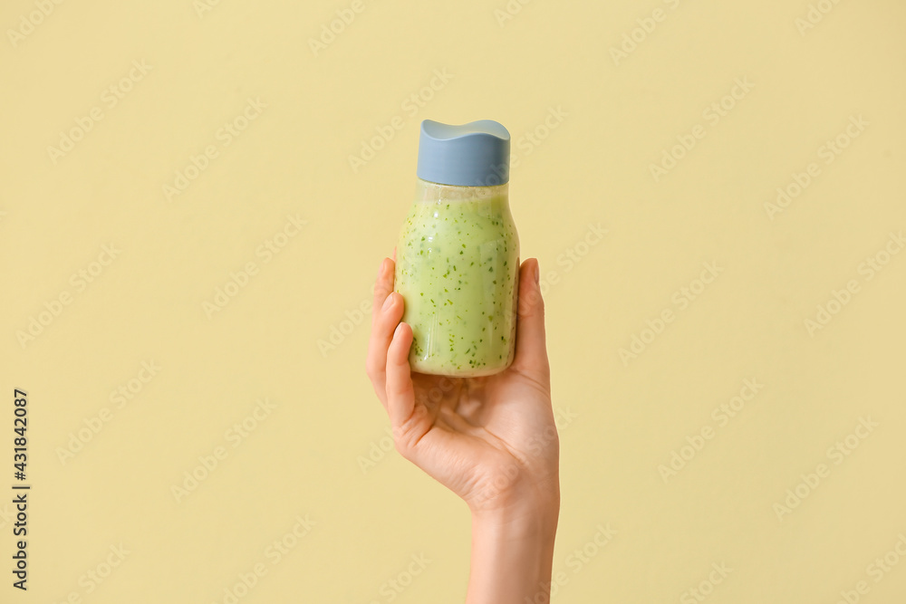 Woman with bottle of fruit smoothie on color background - obrazy, fototapety, plakaty 