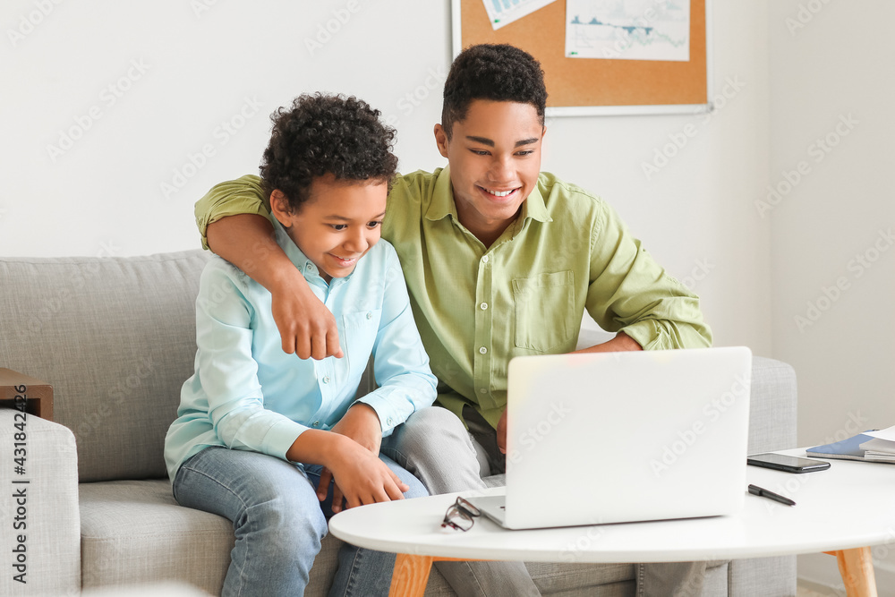 African-American boys using laptop at home African-American boys using laptop at home