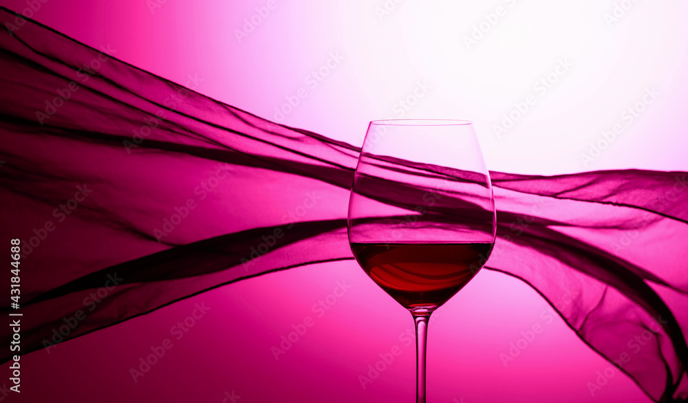 Glass of red wine on a background of waving curtain. - obrazy, fototapety, plakaty 