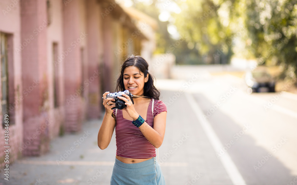Woman on street taking photo.