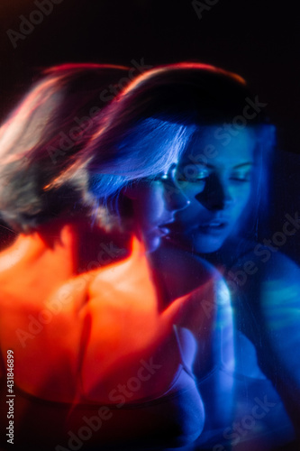 Female hope. Art silhouette. Faith forgiveness. Double exposure abstract portrait of pensive thoughtful worried woman in blue red neon light on dark stained texture effect.