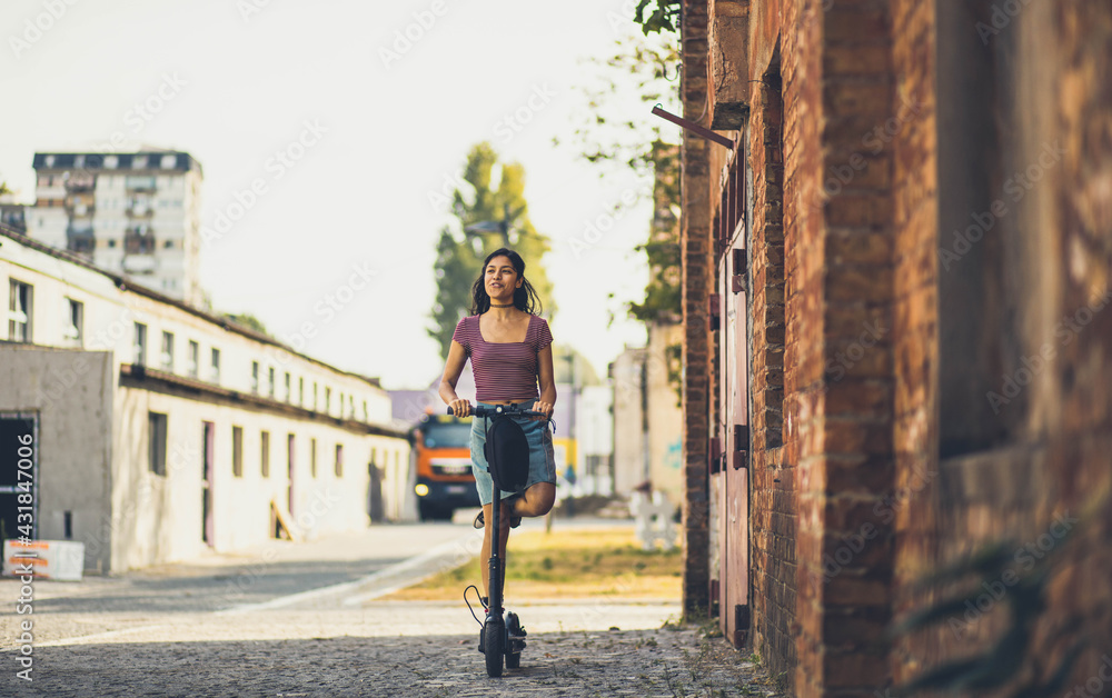 Obraz premium Woman on electric scooter in city.