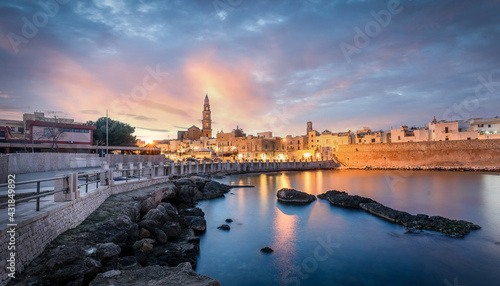 Obraz na plátně Monopoli harbor in the Metropolitan City of Bari and region of Apulia (Puglia), Italy at sunset and beautiful illuminated cathedral Basilica Concattedrale Maria Santissima della Madia
