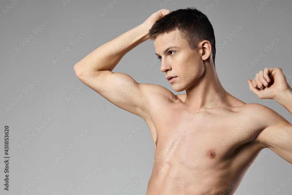 athlete with naked torso showing arm muscles on gray background cropped view athlete with naked torso showing arm muscles on gray background cropped view