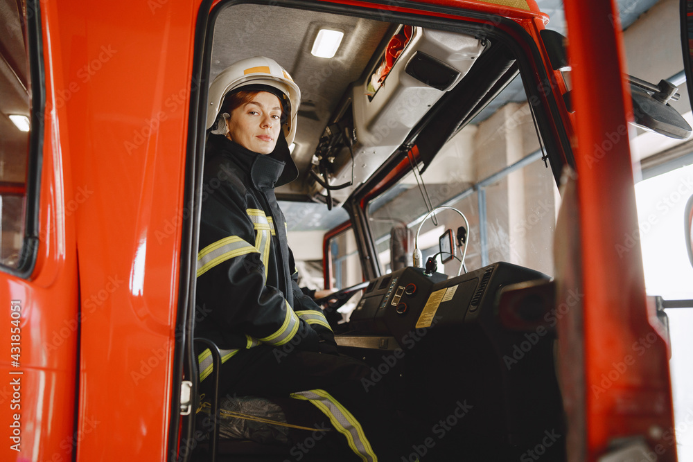 Naklejka premium Firefighters in a fire truck in uniform