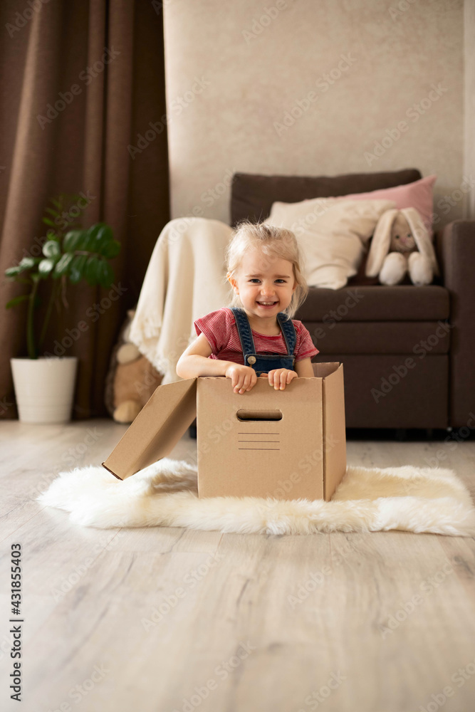 A little girl sits in a cardboard box and fantasizes about the game. A little girl sits in a cardboard box and fantasizes about the game.