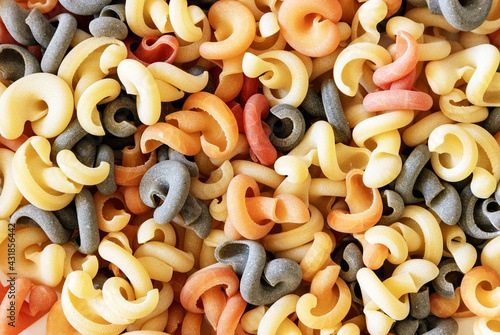 Italian green multicolored pasta with tomato and basil flavor, close-up