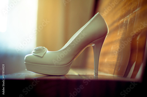 A pair of white shoes sits on top of the piano © licvin