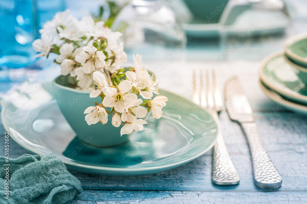Place setting with blooming cherry branch in maritime blue style