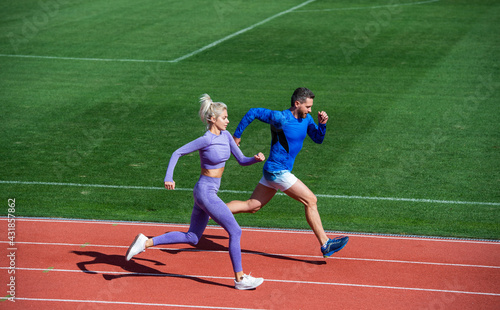 athletic woman and man of sprinters run on running track at stadium, endurance