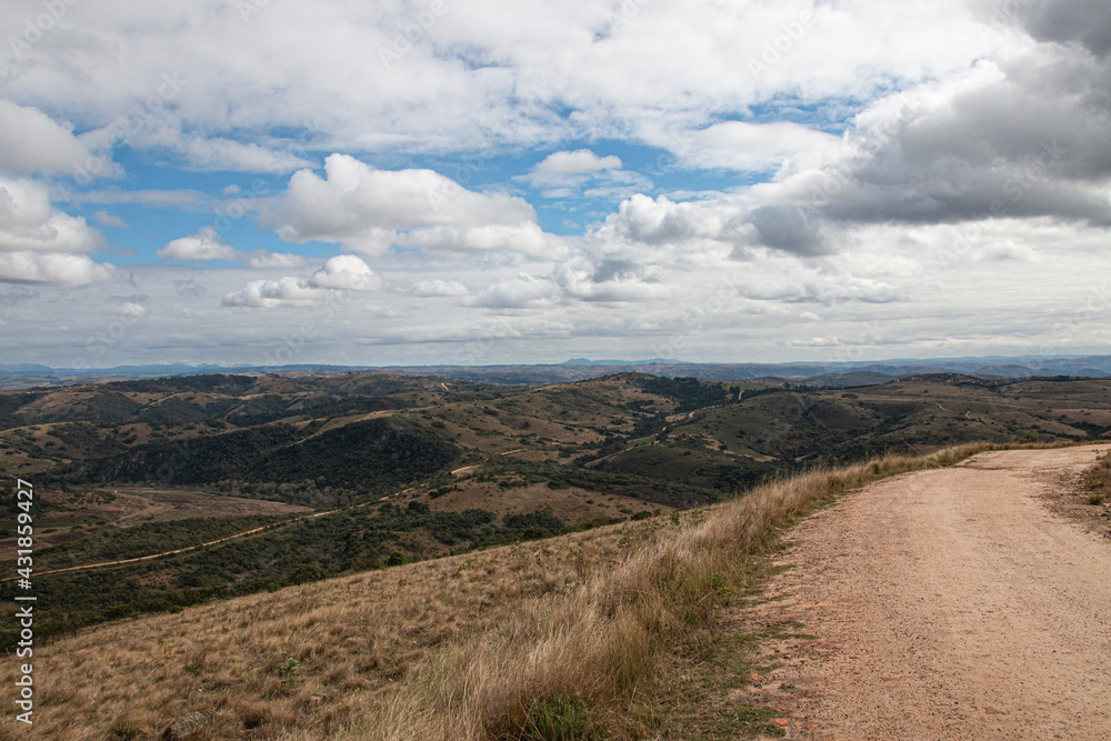 Curved Dirt Road on Hilltop Surrounded by Bleak Landscape Curved Dirt Road on Hilltop Surrounded by Bleak Landscape
