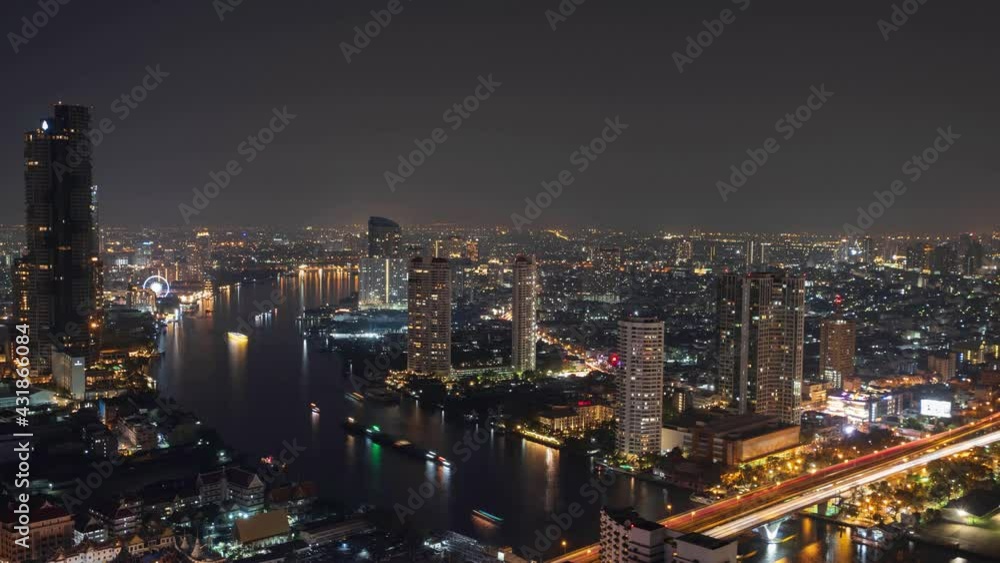 Beautiful 4k aerial time lapse of the many buildings along the highway bridge, Chao Phraya river with a many boats at night Beautiful 4k aerial time lapse of the many buildings along the highway bridge, Chao Phraya river with a many boats at night