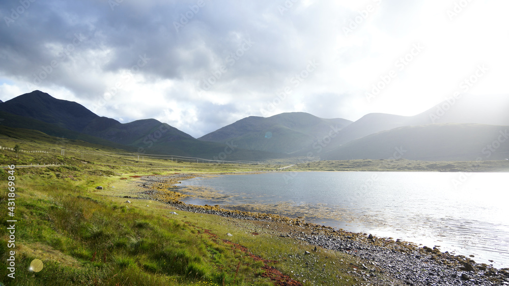 Loch Ainort und Loch na Cairidh auf der Insel Skye mit malerischem gleißendem Sonnenlicht, Bergen und spiegelung im Ufer