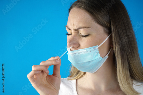 Woman makes nasal swab for rapid test or self test for Corona or Covid-19