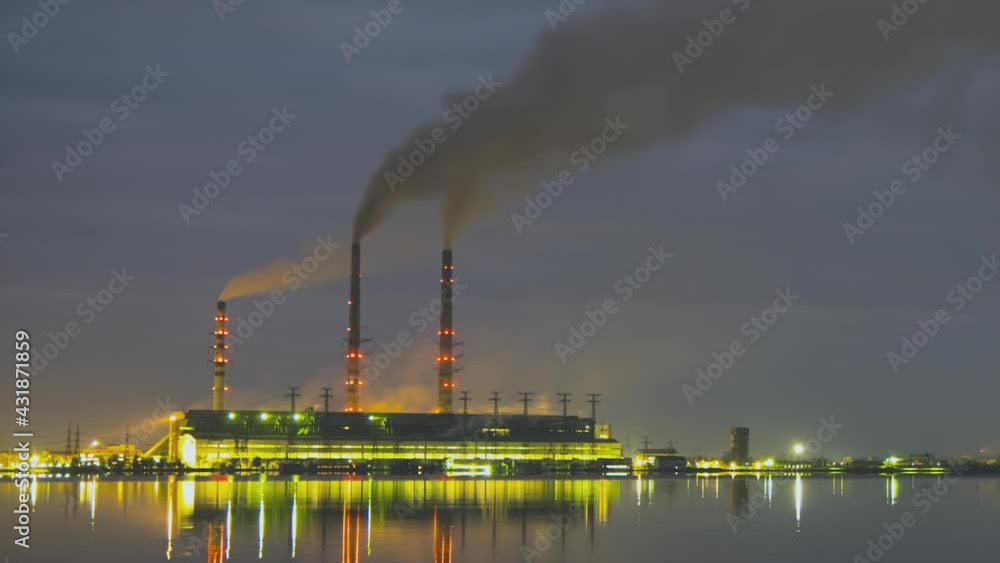 Time lapse of coal power plant high pipes with black smoke moving fast polluting atmosphere at night with reflections of it in lake water. Time lapse of coal power plant high pipes with black smoke moving fast polluting atmosphere at night with reflections of it in lake water.