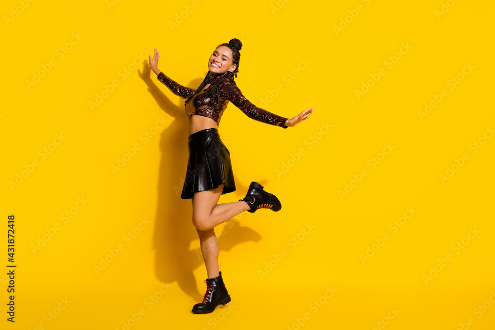 Full length photo of charming pretty dark skin lady wear glamour outfit dancing empty space isolated yellow color background