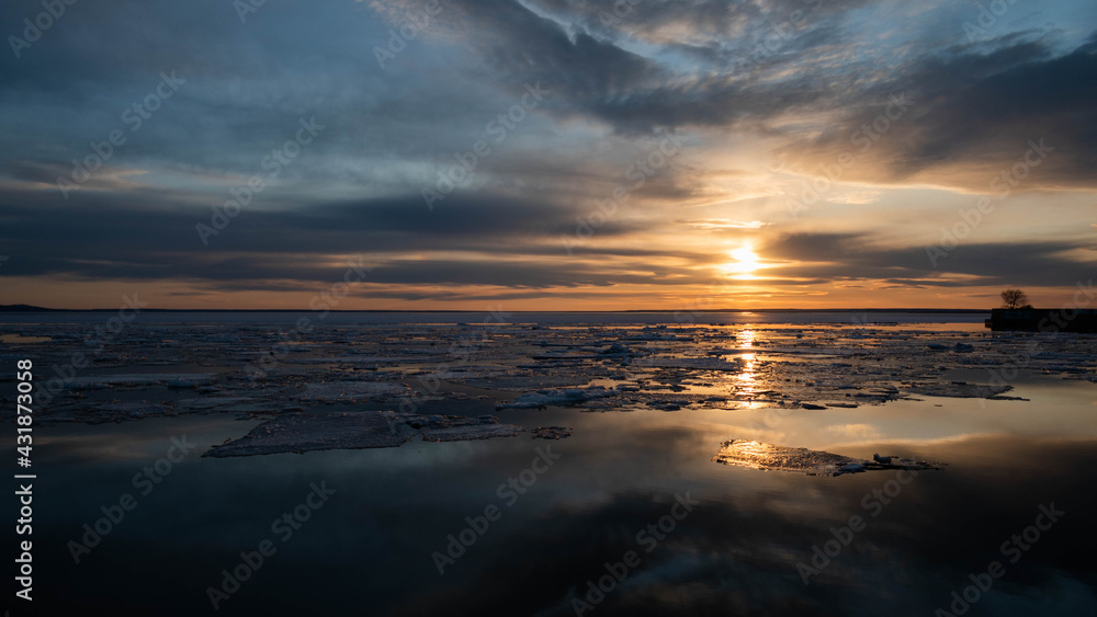 Obraz premium A bright mirror-like sunset with a small island