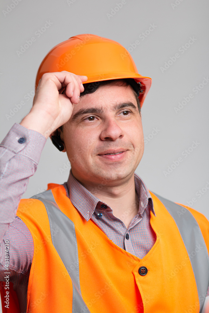 portrait of successful young construction worker in hard hat on grey studio background greeting portrait of successful young construction worker in hard hat on grey studio background greeting