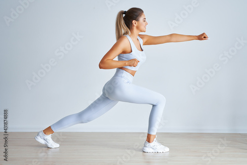 Adult beautiful woman working out over light background