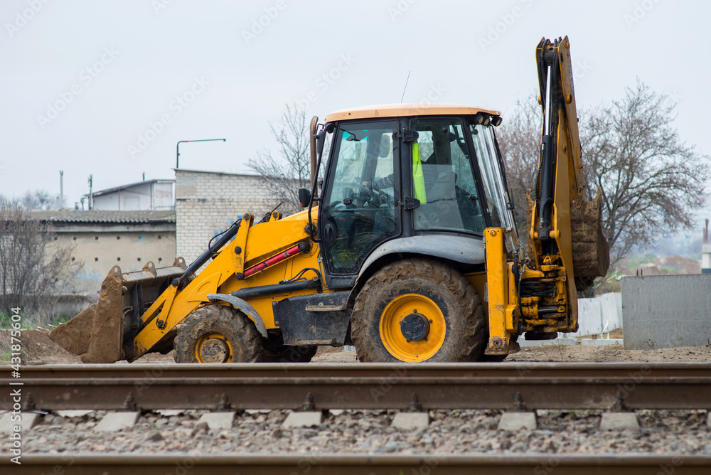 Obraz premium yellow construction excavator moves to a construction site
