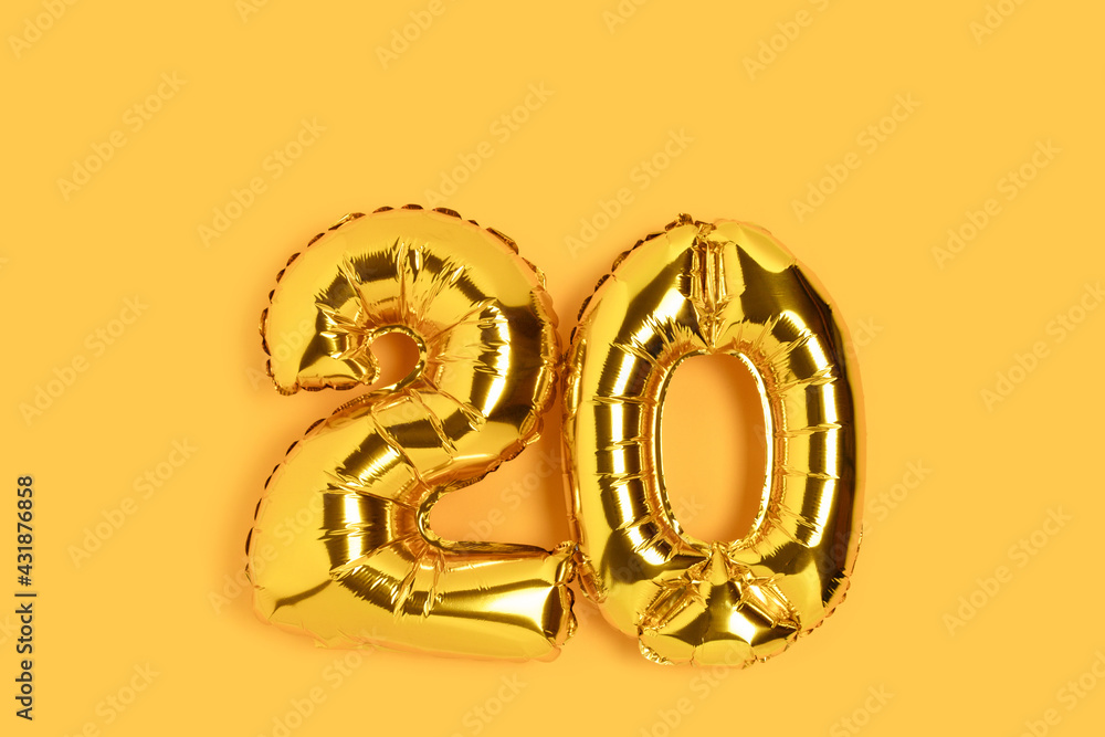 Number 20 golden balloons with copy space. Twenty years anniversary celebration concept on a yellow background. Number 20 golden balloons with copy space. Twenty years anniversary celebration concept on a yellow background.