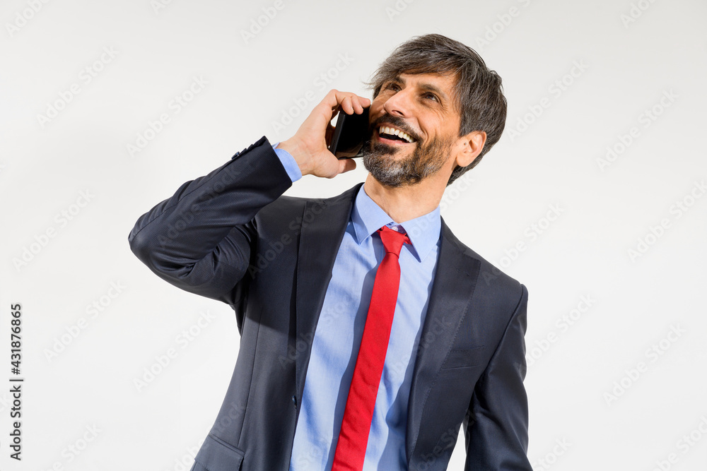 Smiling businessman in jacket using mobile phone on white Smiling businessman in jacket using mobile phone on white