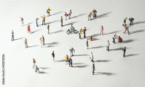 Top view of people (miniature toys) with long shadows keep distance away in public during sunrise or sunset.Social distancing during COVID-19 coronavirus outbreak spreading concept.