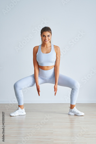 Adult beautiful woman working out over light background