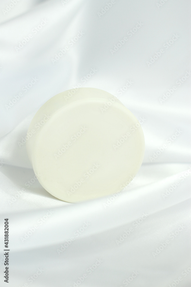 White solid soap shampoo bar on silk background, bath cosmetics White solid soap shampoo bar on silk background, bath cosmetics