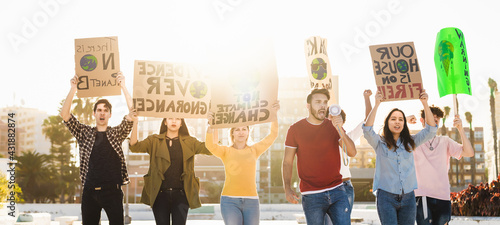 Demonstrators group protesting against plastic pollution and climate change - Multiracial people fighting on road holding banners on environments disasters - Global warming concept photo