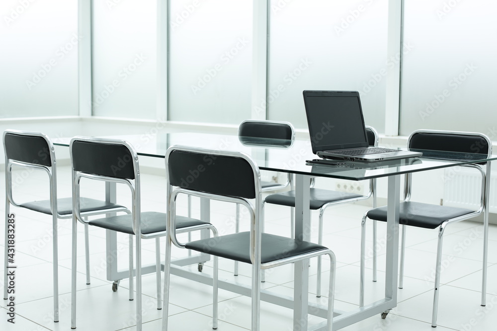 Fototapeta premium Laptop on glass table in office bright space