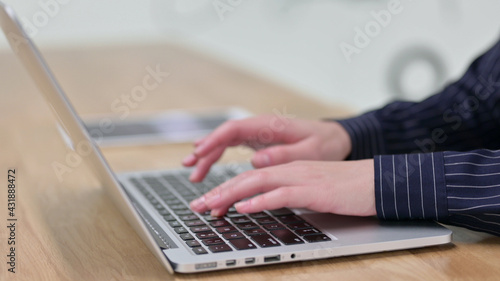 Businesswoman Typing on Laptop at Work