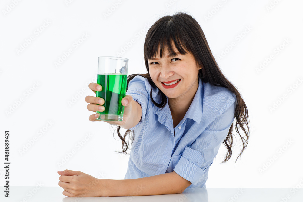 Friendly long-hair lady with charming smile and eyes in a blue shirt. Look at camera holding a juice green glass. Portrait with white background. Feel fresh, fun, refreshing, healthy.