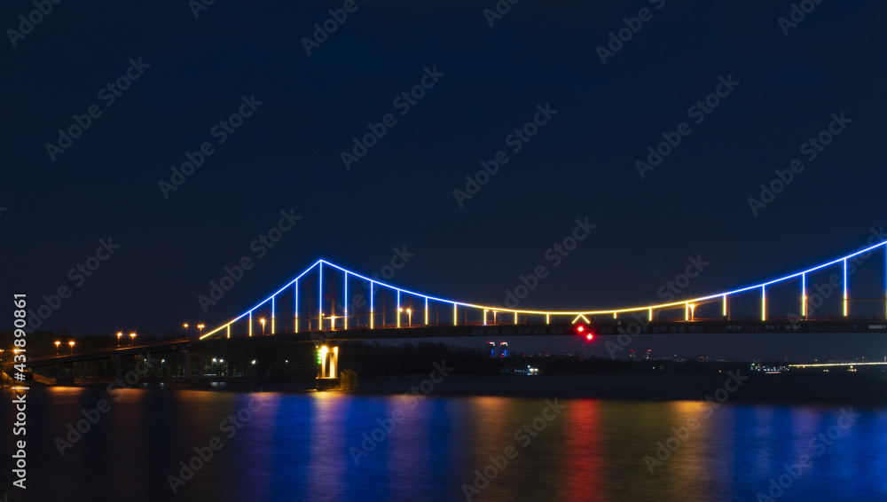photo of a bridge with lights reflected in the water