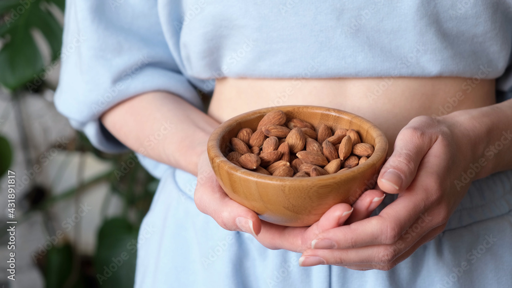 Unrecognizable Woman holding bowl of almonds. Healthy vegan keto diet snack food Unrecognizable Woman holding bowl of almonds. Healthy vegan keto diet snack food