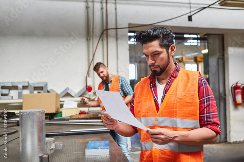Warehouse clerk and order picker reads an order photo