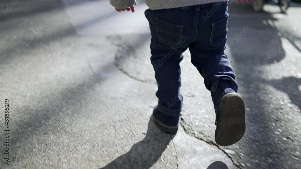 Little boy running outside at city sidewalk. Energetic child runs Little boy running outside at city sidewalk. Energetic child runs