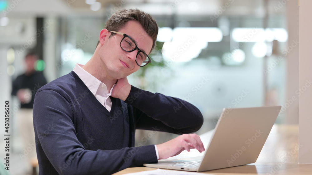 Tired Young Businessman with Laptop having Neck Pain Tired Young Businessman with Laptop having Neck Pain