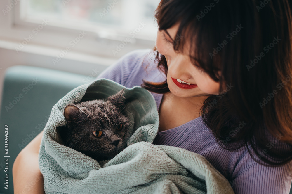 Obraz premium The beautiful girl was drying her cat's fur