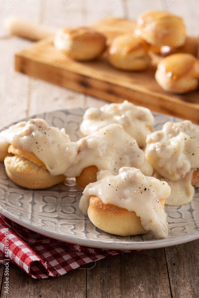 Traditional American biscuits and gravy for breakfast on wooden table	