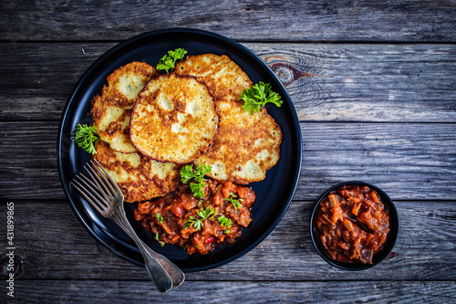 Potato pancakes with vegetable stew on wooden table 