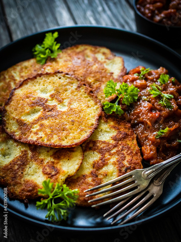 Potato pancakes with vegetable stew on wooden table 