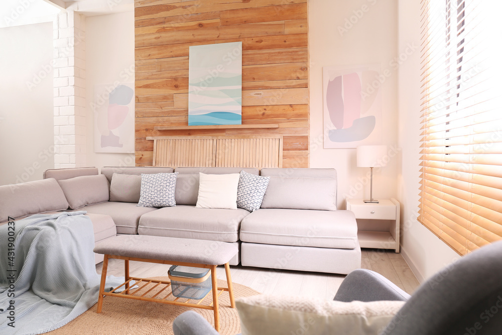 Fototapeta premium Stylish living room interior with comfortable sofa and pictures