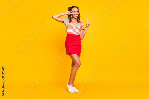 Fototapeta Naklejka Na Ścianę i Meble -  Full length photo of girl two hands show v-sign wear striped shirt mini skirt shoes isolated yellow color background