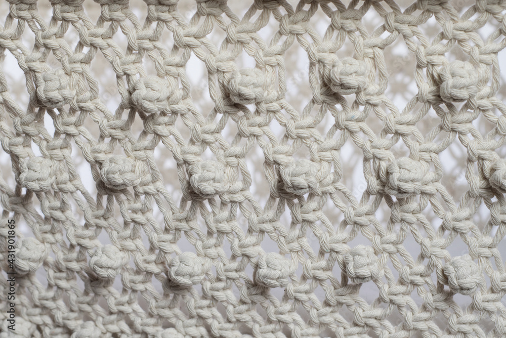 Weaving texture in macrame style from white natural cotton threads. Weaving texture in macrame style from white natural cotton threads.