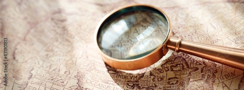 Retro copper colored magnifying glass and old white nautical chart close-up. Vintage still life. Sailing accessories. Travel, navigation concepts, collecting, graphic resource, hand lens, optics