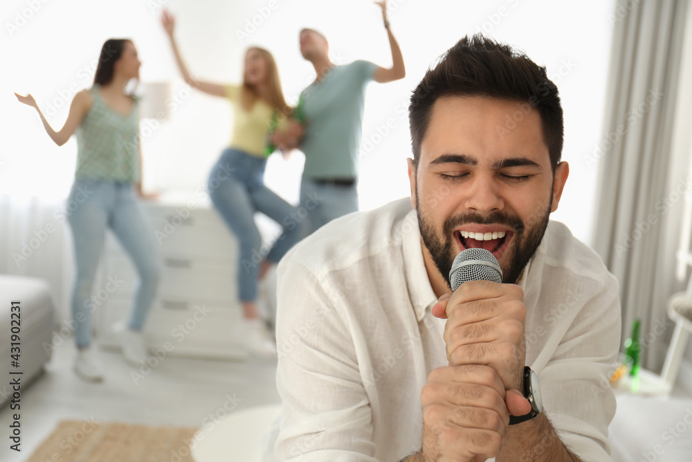 Young man singing karaoke with friends at home Young man singing karaoke with friends at home