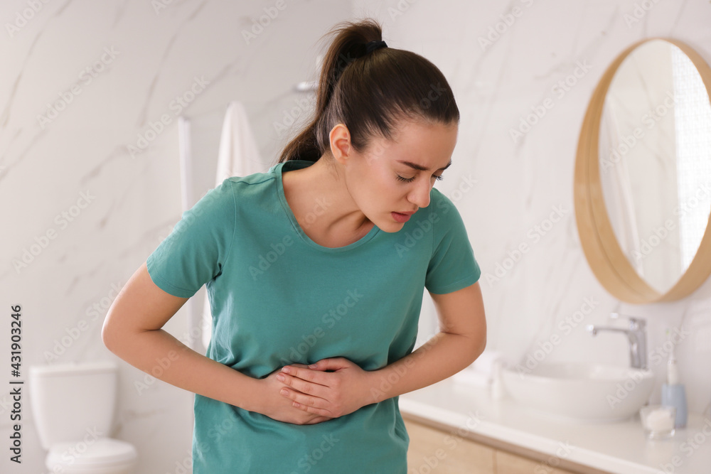 Young woman suffering from stomach ache in bathroom. Food poisoning Young woman suffering from stomach ache in bathroom. Food poisoning