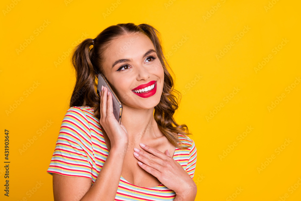 Portrait of attractive cheerful girl using gadget talking on phone enjoying good news isolated over bright yellow color background Portrait of attractive cheerful girl using gadget talking on phone enjoying good news isolated over bright yellow color background